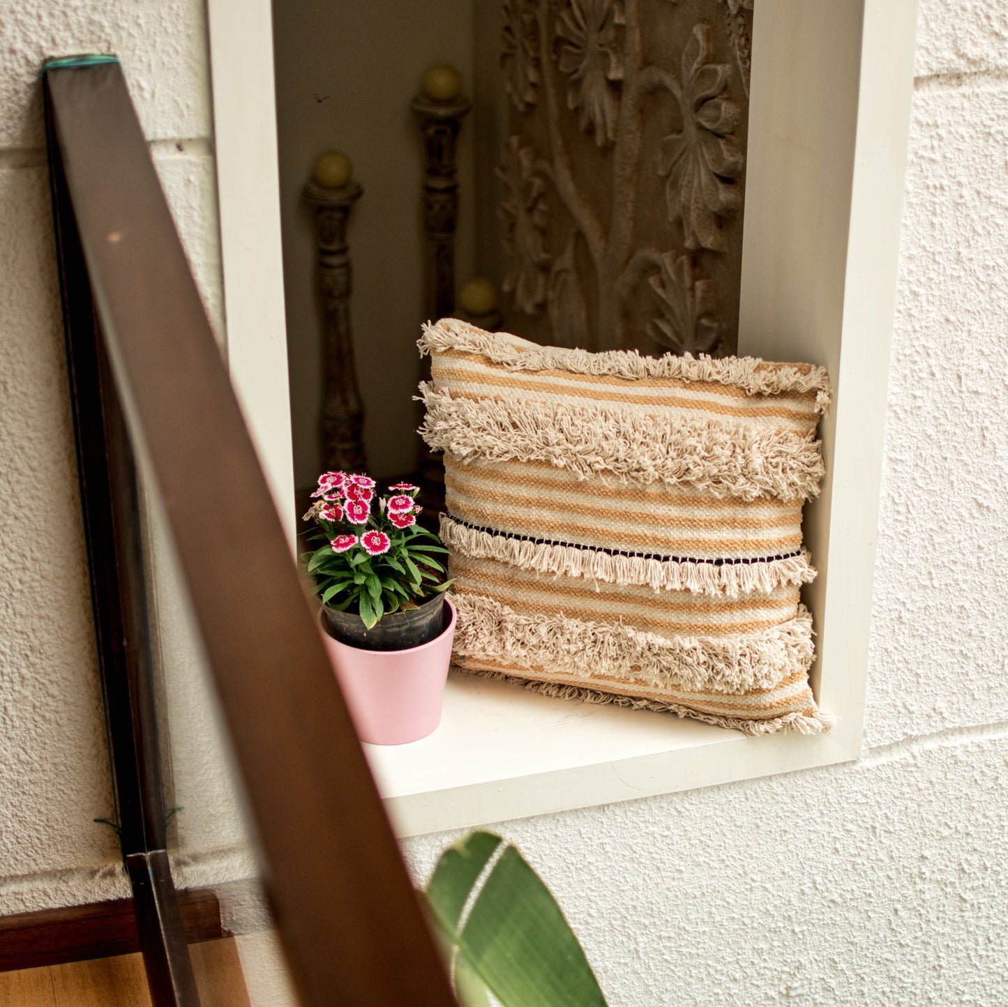 Avicia Bohemian throw pillow, placed in a wall niche beside a planter to show it's compatibleness with natural as well as manmade settings.