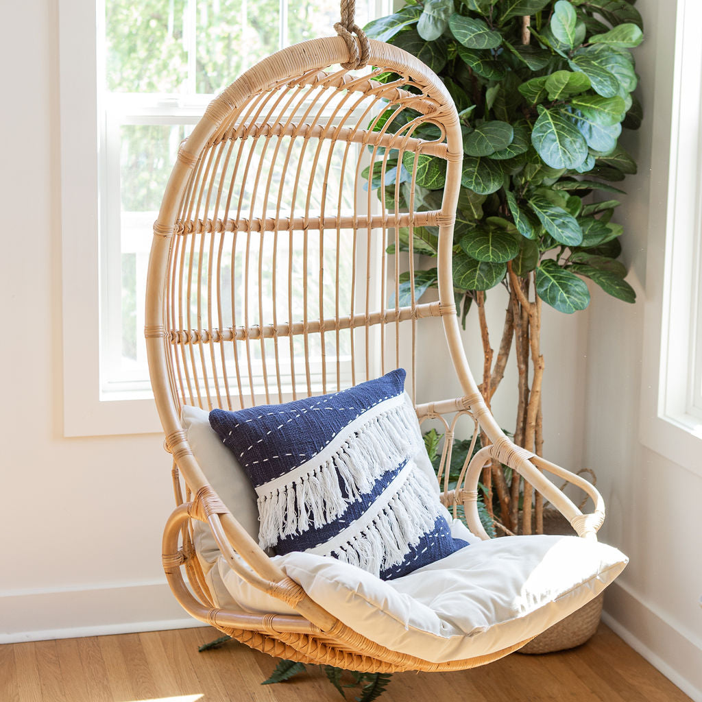 Bohemian decor inspiration with swing complimented by blue chic throw pillow and planters in the background