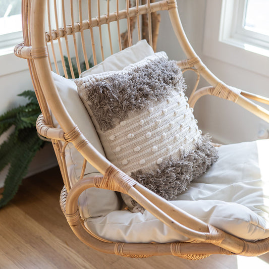 Aarohi bohemian throw pillow on a cane swing for the perfect cozy book reading corner.